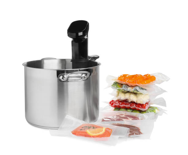 istock Thermal immersion circulator in pot and vacuum packs with different food products on white background. Sous vide cooking 1490450585