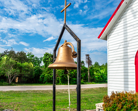 Very old church bell in front of a small church in Texas