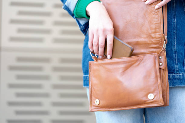 istock Female hand putting modern smartphone in bag 1490457663