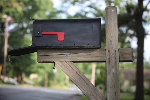 Black mailbox with red flag, low angle, narrow depth of field, soft lighting