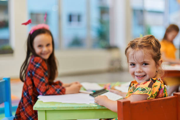 istock Creative kids during an art class in a daycare center or elementary school classroom drawing with female teacher. 1490460749