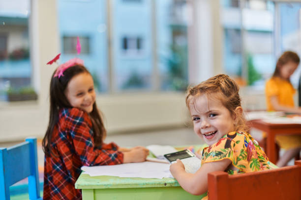 istock Creative kids during an art class in a daycare center or elementary school classroom drawing with female teacher. 1490460907