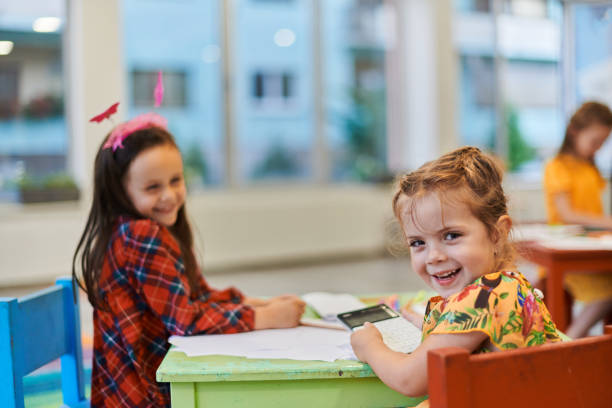 istock Creative kids during an art class in a daycare center or elementary school classroom drawing with female teacher. 1490460969