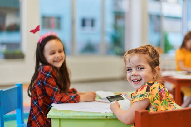 istock Creative kids during an art class in a daycare center or elementary school classroom drawing with female teacher. 1490461037