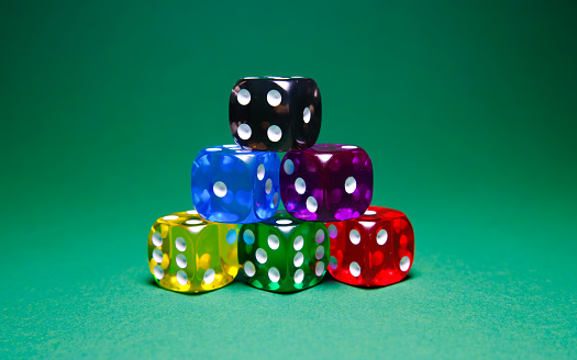colored dice on green table background