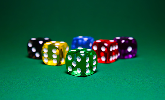 colored dice on green table background