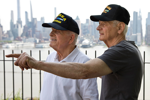 Korean War Veteran and Vietnam Veteran on a sunny day with New York City in the background.