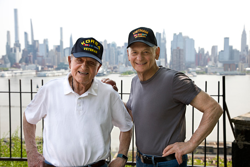 Korean War Veteran and Vietnam Veteran on a sunny day with New York City in the background.