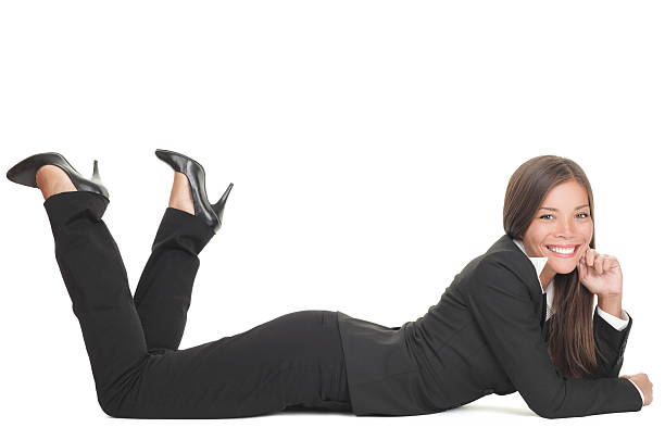 Business woman lying down isolated Business woman lying down on floor isolated on white smiling looking at camera. Young mixed race Chinese Asian Caucasian businesswoman.Click for more: woman lying on the floor isolated stock pictures, royalty-free photos & images