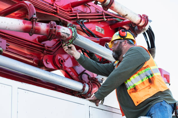 istock Man inspecting pipe clamp on a concrete boom pump truck 1490467312