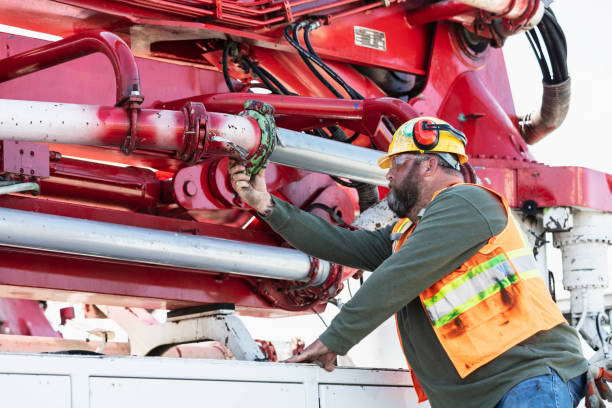 istock Man inspecting pipe clamp on a concrete boom pump truck 1490467318