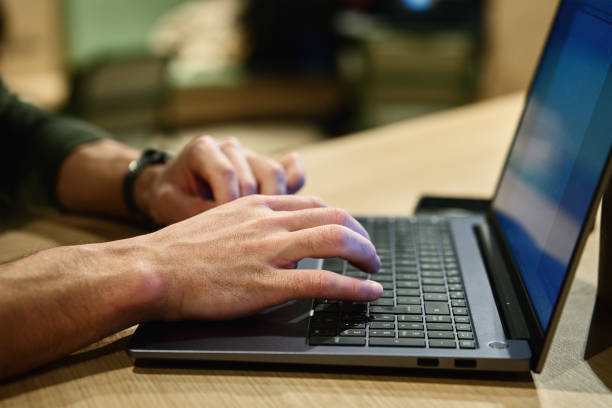 istock Male hand typing on laptop keyboard in cafe 1490467803