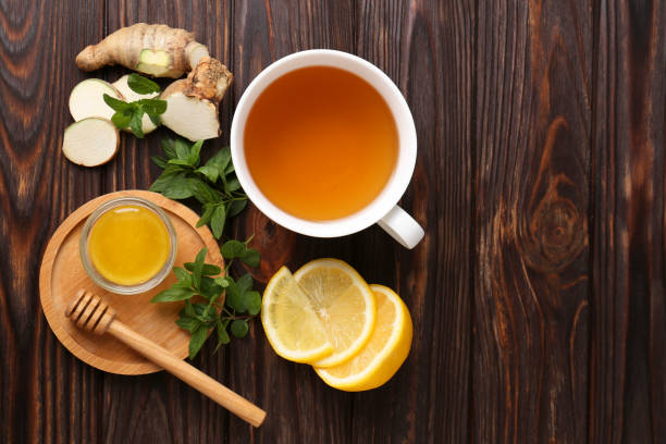 istock Flat lay composition of tea with mint, honey, lemon and ginger on wooden table. Space for text 1490469941