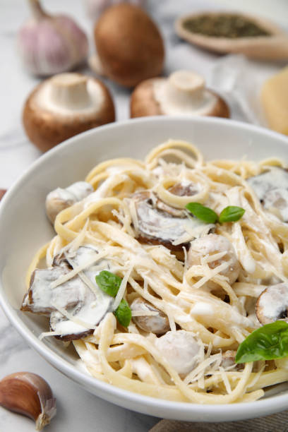 istock Delicious pasta with mushrooms on white table, closeup 1490470099