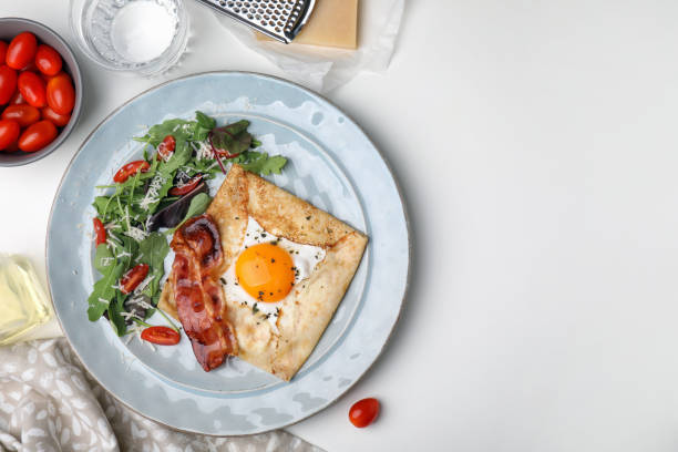 istock Delicious crepe with egg served on white table, flat lay with space for text. Breton galette 1490470125