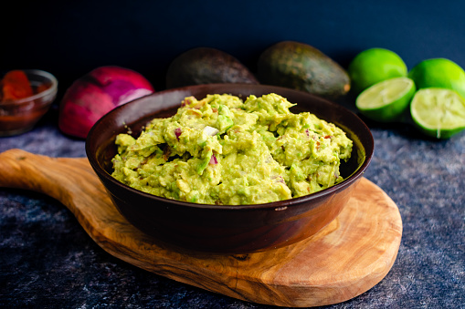 Homemade guacamole with avocados, limes, onion, cilantro, and chipotle peppers