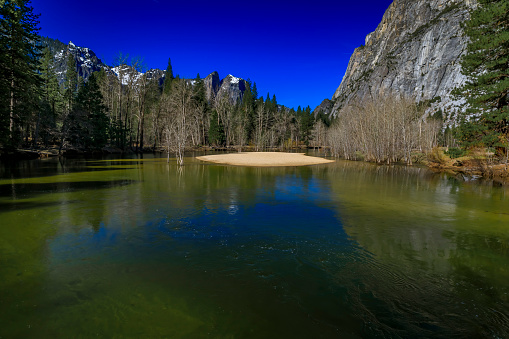 Merced river full after snow melt in the spring, famous Yosemite Valley in the Yosemite National Park, Sierra Nevada mountain range in California, USA
