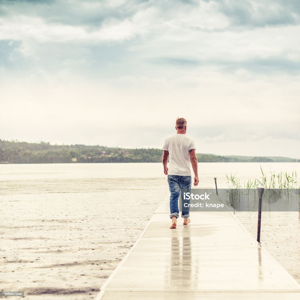Hombre caminando en un embarcadero - Foto de stock de 30-34 años libre de derechos