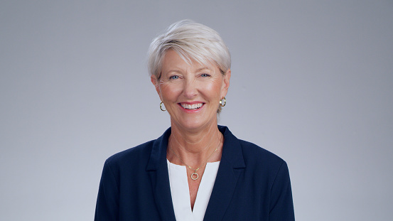 Happy, mature and portrait of a woman in business isolated on a white background in a studio. Corporate headshot, smile and a company manager with pride, happiness and smiling for agency profile