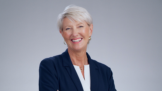 Happy, mature and portrait of a corporate woman isolated on a white background in a studio. Business headshot, smile and a company manager with pride, happiness and smiling for agency profile