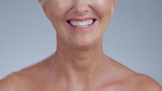 Smile, skincare and neck of senior woman in studio for cosmetics, treatment or dermatology on grey background. Body care, beauty and elderly lady model happy with anti aging, glow or satisfaction