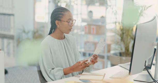istock Report, proposal and a business woman reading documents while working alone at a desk in her office. Planning, information and paper with an african female employee checking a page of data at work 1490475813