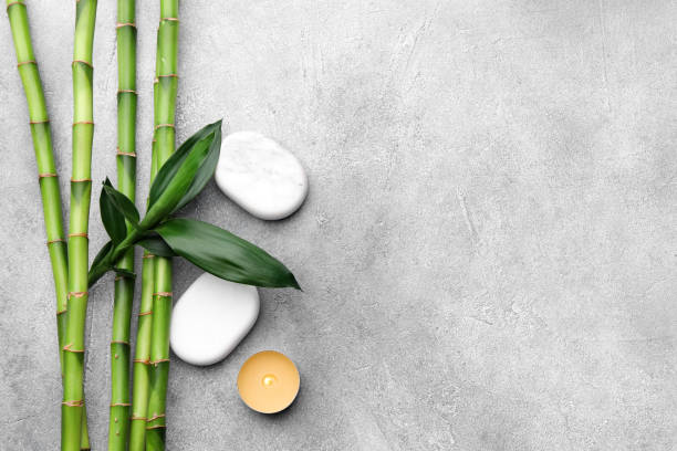 istock Spa stones, bamboo and burning candle on light grey table, flat lay. Space for text 1490476823