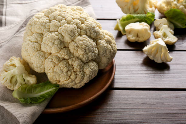 istock Plate with fresh raw cauliflower on wooden table. Space for text 1490480191