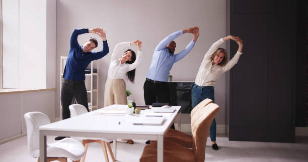 istock Happy Businesspeople Doing Stretching Exercise Behind Desk 1490481688