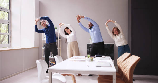 istock Happy Businesspeople Doing Stretching Exercise Behind Desk 1490481705