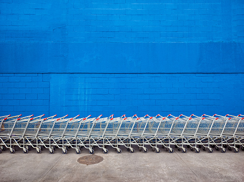 supermarket carts lined up in front of a blue wall