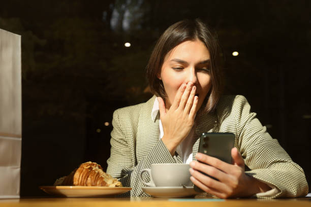 istock Special Promotion. Emotional young woman using smartphone at table in cafe 1490486993