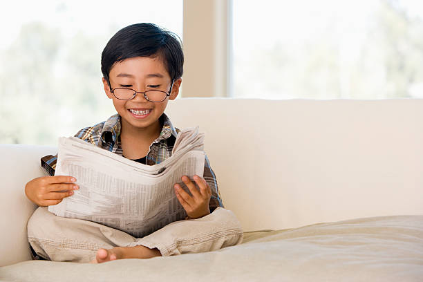 Young Boy Sitting On A Sofa At Home