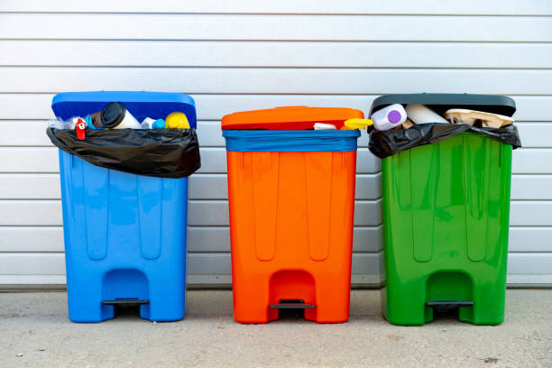 istock Three trash containers full of garbage near the building 1490490844