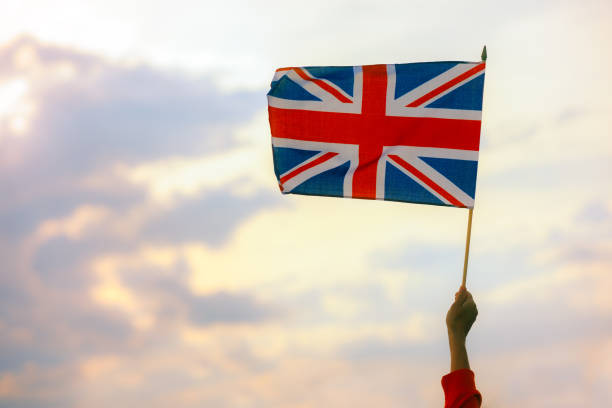 Agitant la main du drapeau du Royaume-Uni dans le ciel - Photo