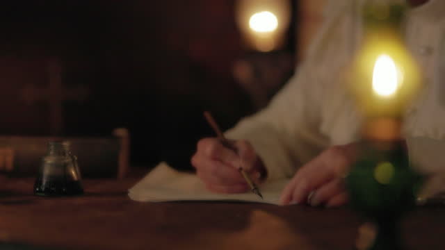 Woman writing by oil lamp light using dip pen