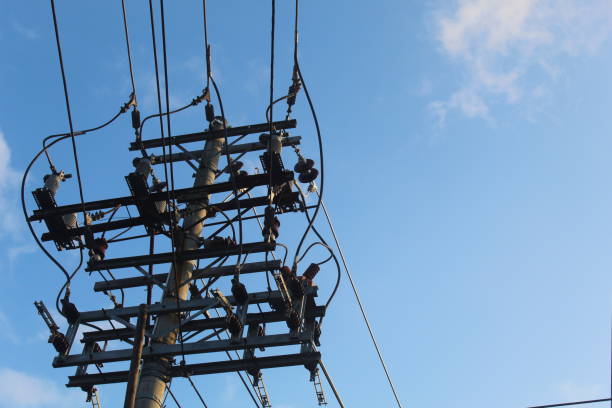 istock neatly organized electric poles and power cables with a bright blue sky background 1490503884