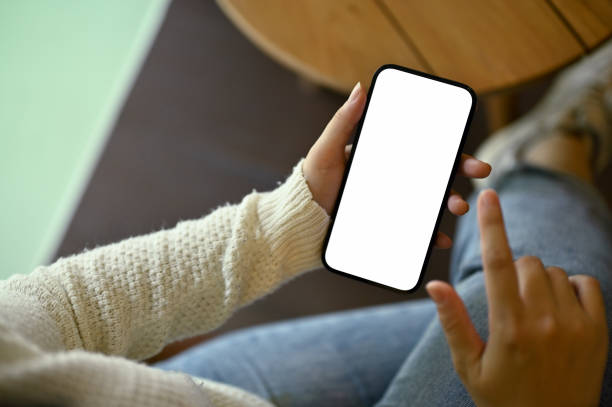 istock A woman in cozy white sweater using her smartphone while relaxing in a room. 1490505678