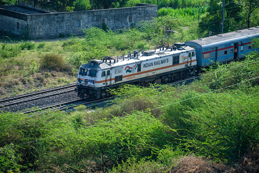 Pune, India - May 14 2023: Passenger train hauled by a WAP7 Electric locomotive at Uruli near Pune India.