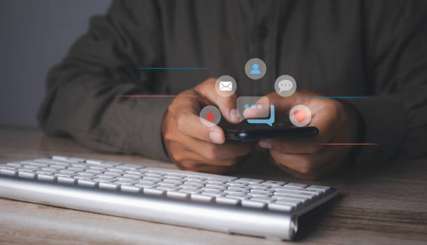istock man using smartphone with social media to interactions icon on internet post. 1490507915