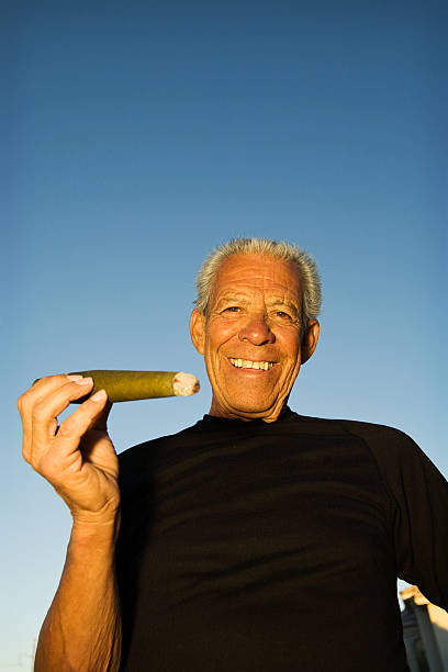 Man and his Cigar A man smiling at you holding his big cigar cuban man smoking big cigar stock pictures, royalty-free photos & images