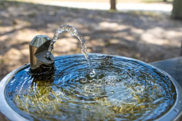 A water fountain runs in a public park.