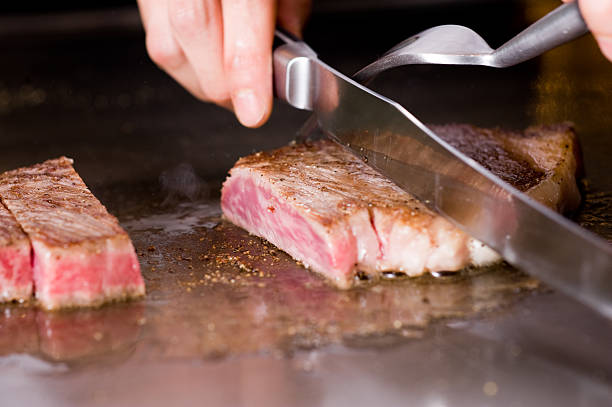 Ribeye steak Cutting a ribeye steak griddle stock pictures, royalty-free photos & images