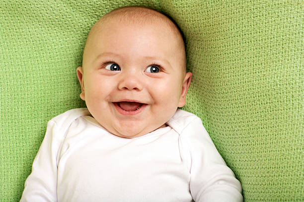 Joyful Baby Boy adorable baby boy smiling on a green blanket baby stock pictures, royalty-free photos & images