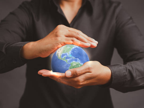 istock Young man holding the earth while standing against a gray background. 1490518817