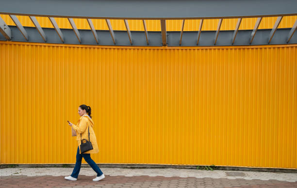 Latin woman outdoors wearing a yellow rain coat in a minimalist style photography