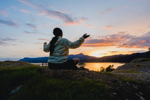 Hispanic Woman Meditating During Sunset In the Mountains - fotografia de stock