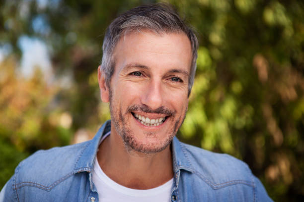 istock Portrait of grey-haired middle aged man smiling at camera 1490529993