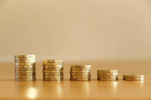 Stacks of decreasing UK one pound coins Close up of stacks of many UK sterling one pound coins decreasing in size as money going down and getting poorer british currency stock pictures, royalty-free photos & images