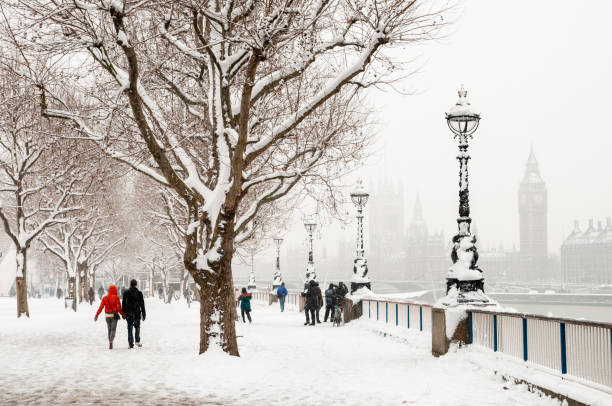 Cold winter weather brings snow  to the banks of the river Thames, London, UK